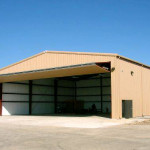 Sagebrush Tan steel airplane hangar with open garage door
