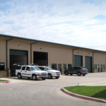 Steel building office and shop combination with green garage doors