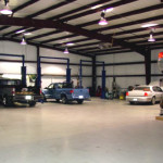 Inside automotive shop with steel framing and cars