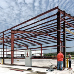 Warehouse under construction with red steel framing
