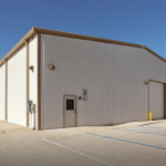 White commercial steel building with parking lot