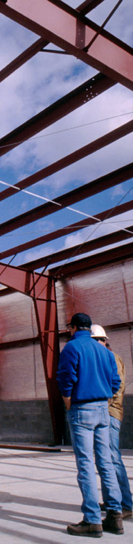 Commercial steel building framers inside a pre-engineered metal building under construction