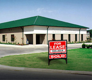 Photo of a RHINO commercial steel building with brick exterior and a green metal hip roof.