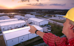 A builder points to a business park of commercial steel buildings.