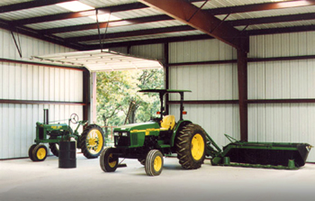 Tractors and farm equipment parked inside an attractive prefab metal barn from RHINO Steel Building Systems.