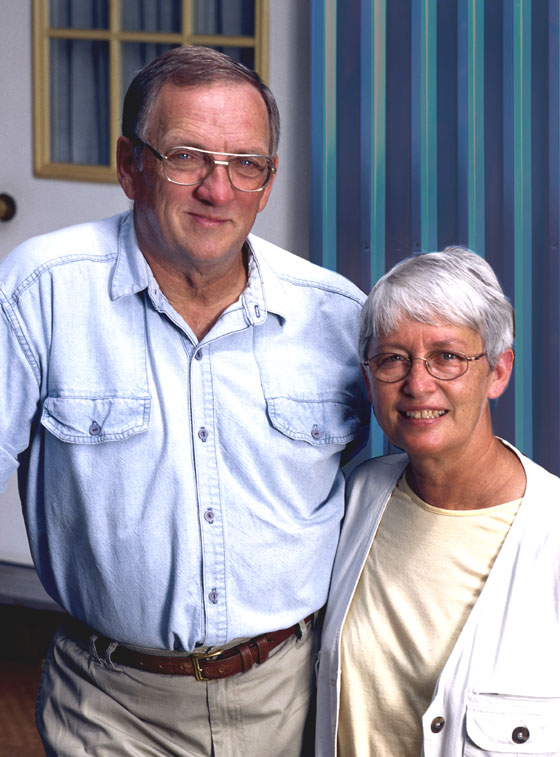 Older couple stands before their metal building guest house