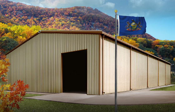 Pennsylvania state flag flies before a metal building standing before a forest of fall colors