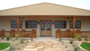 An attractive steel home with covered porch and cedar trim