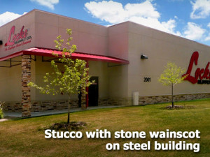 RHINO steel building finished in tan stucco with tan-and-brown stone trim