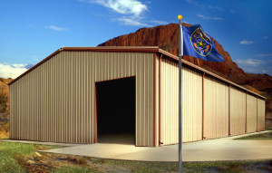 A tan and brown metal buildings stands before the rugged red rocks of Utah