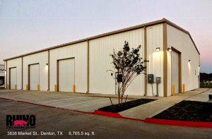 Photo taken at dusk of a white industrial steel building in Denton, Texas