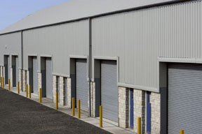 Photo of a gray metallic warehouse with stone trim.