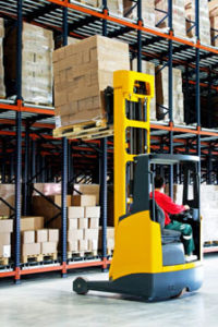 Photo of a warehouse worker using a forklift.