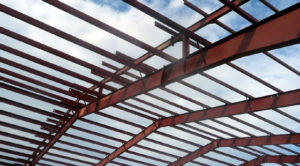 Photo of blue sky seen through steel rafters of a RHINO building under construction.