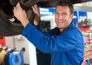 Smiling mechanic mounting a tire.
