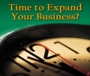 Close-up of a ticking clock with the question "Time to Expand Your Business?"