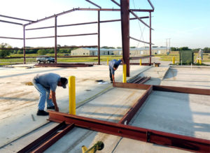 Photo of two men constructing a RHINO metal building frame.