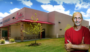 Photo of a building supplier standing before his RHINO electrical supply store. 