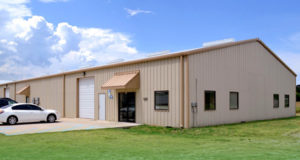 Photo of a medium-sized metal building with canopied glass doors.