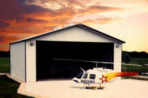 Photo of a helicopter before a RHINO steel hangar.