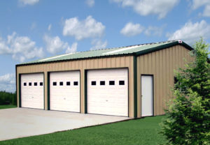 Photo of a tan three-bay metal garage with a dark green roof and trim.