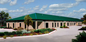 Photo of a bricked RHINO commercial steel building with a metal hip roof.