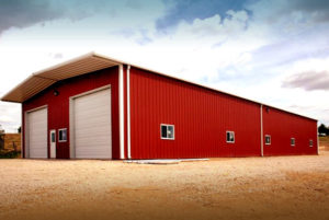 Bright red storage building with white trim and two overhead doors.