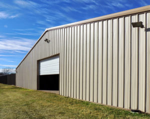 Photo of a large RHINO steel building with a single large opening and an overhead door.
